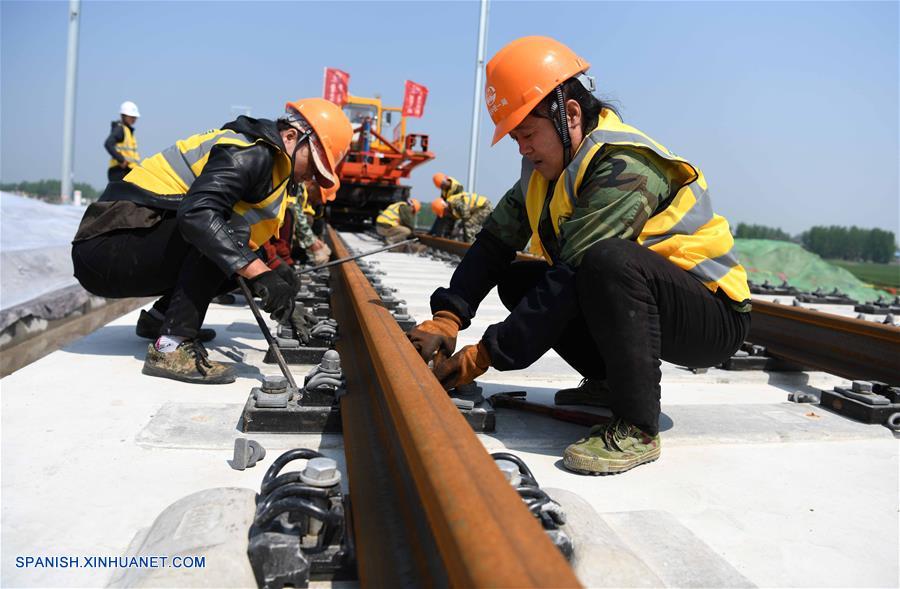Trabajadores colocan vías en la Estación Ferroviaria de Jieshou Sur del Ferrocarril Zhengzhou-Fuyang